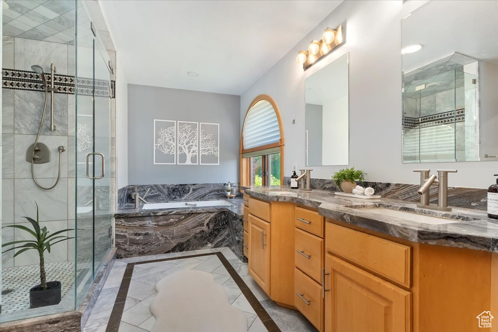 Full bath with a bath, inlaid floor details, a shower stall, and vanity