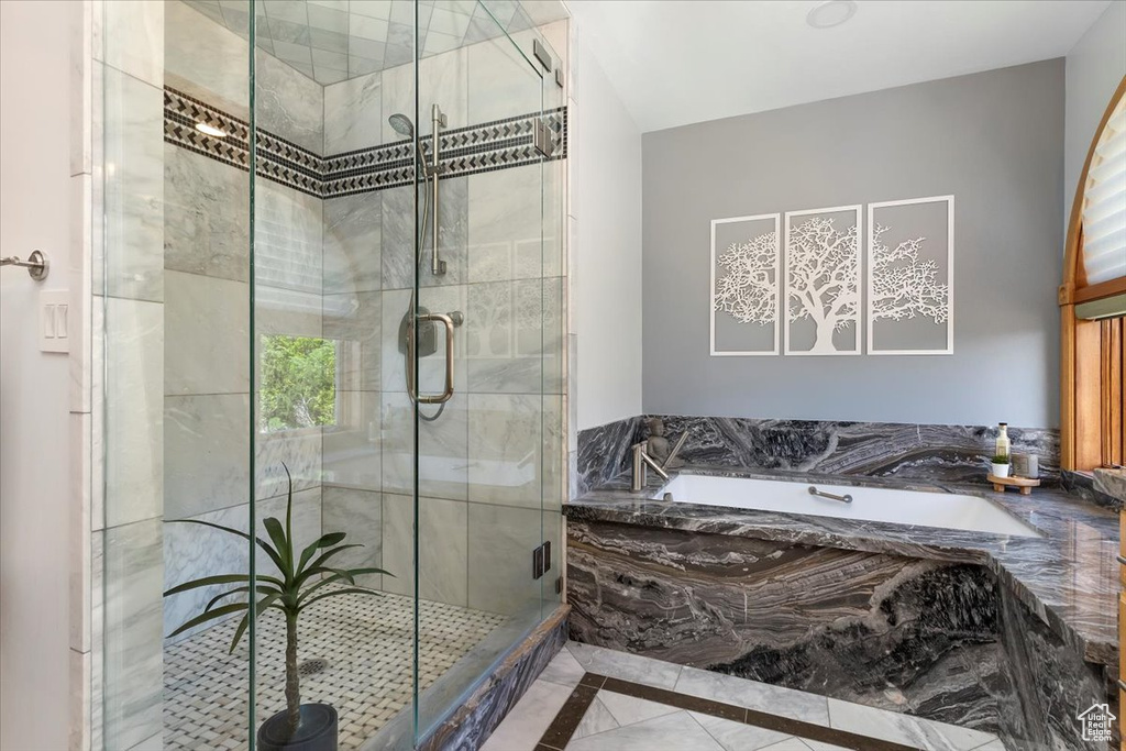 Full bathroom featuring a bath, inlaid floor details, and a stall shower