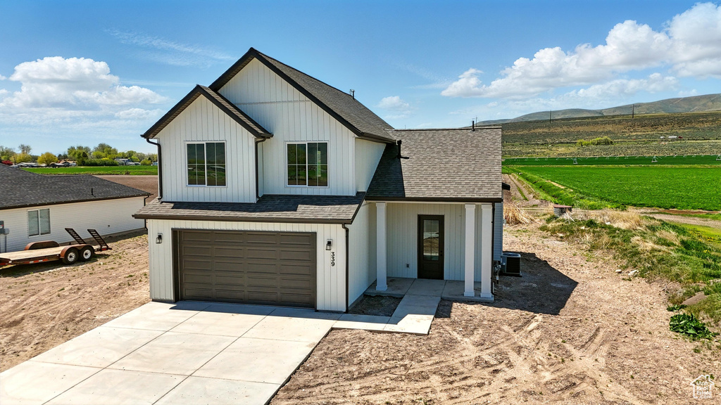 Modern farmhouse style home with concrete driveway, a shingled roof, a mountain view, and an attached garage