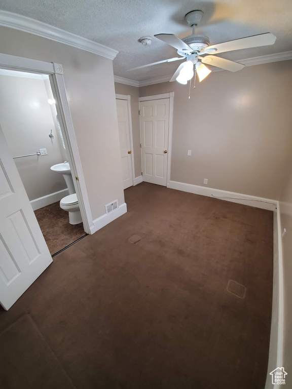 Unfurnished bedroom featuring ornamental molding, connected bathroom, carpet flooring, baseboards, and ceiling fan