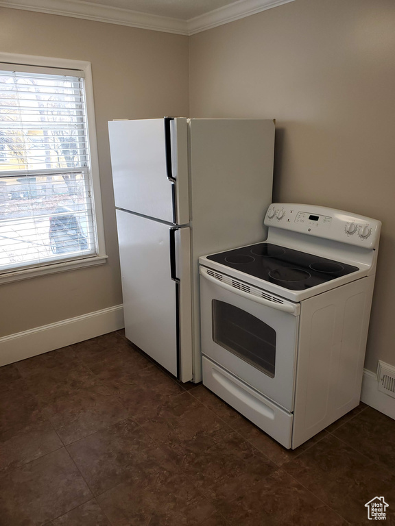Kitchen featuring electric range, crown molding, and baseboards