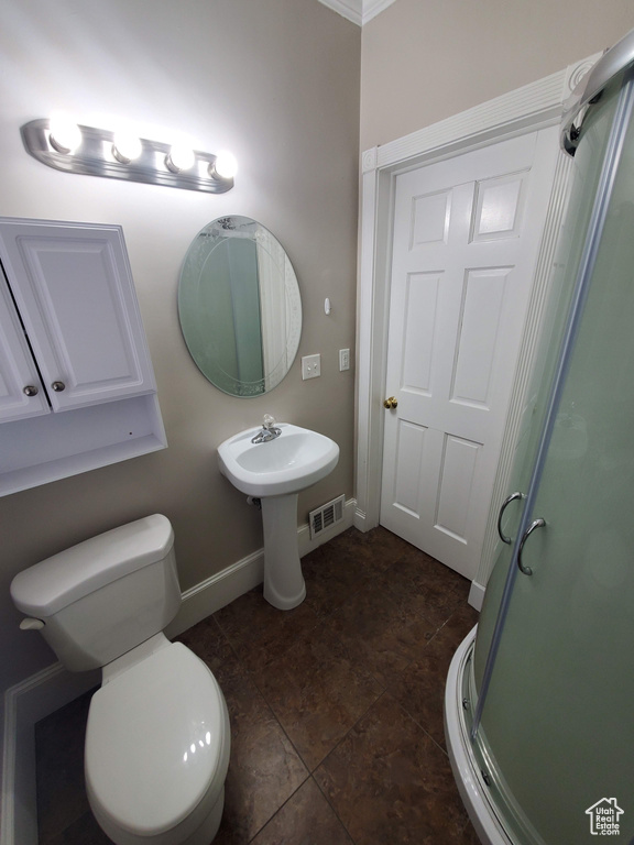 Bathroom with a shower stall, baseboards, and toilet