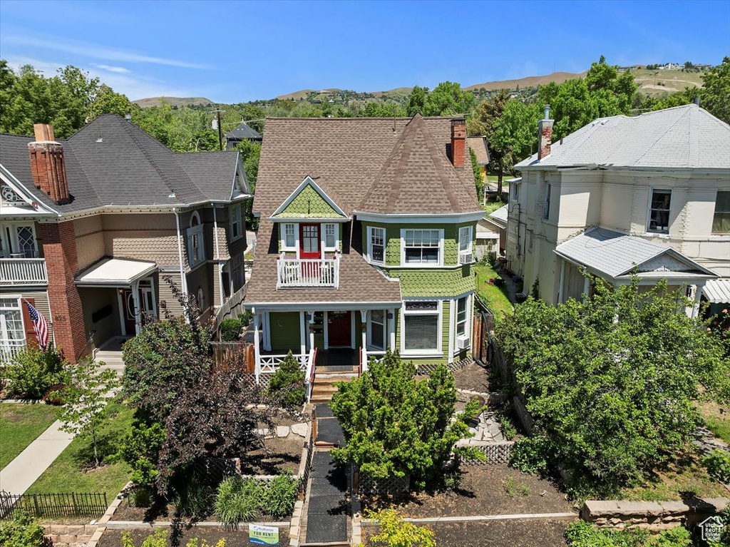 View of front of house with a balcony, a mountain view, and a porch