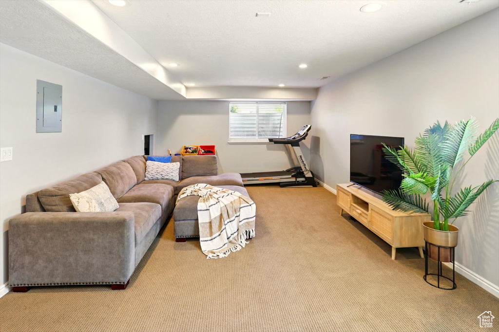 Carpeted living room featuring electric panel, recessed lighting, and baseboards