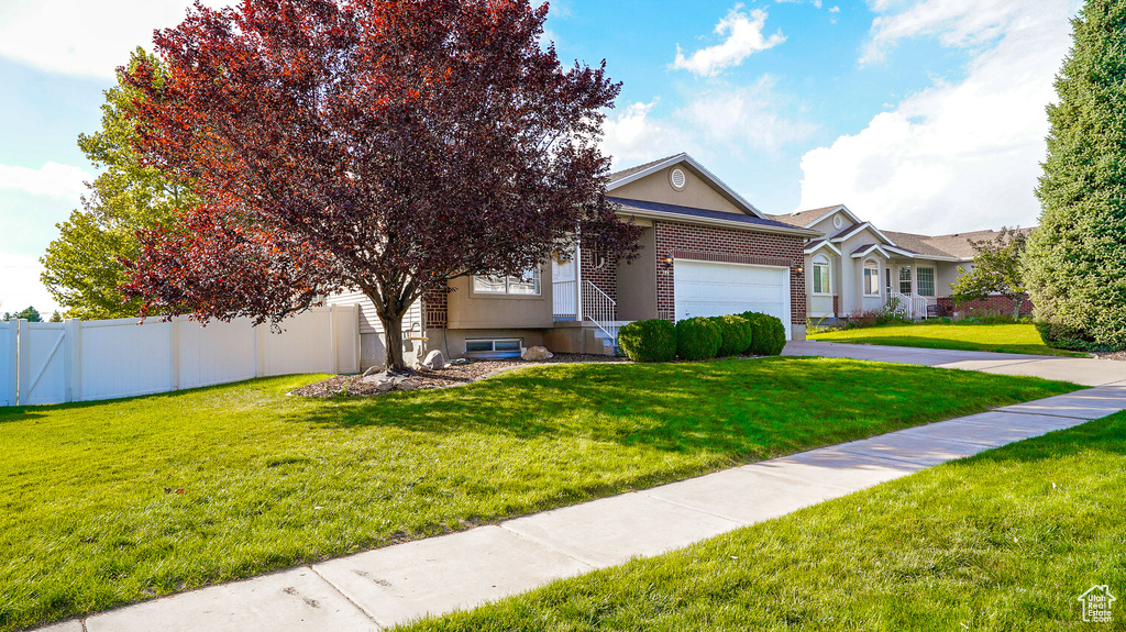 View of front of house with an attached garage, asphalt driveway, and brick siding