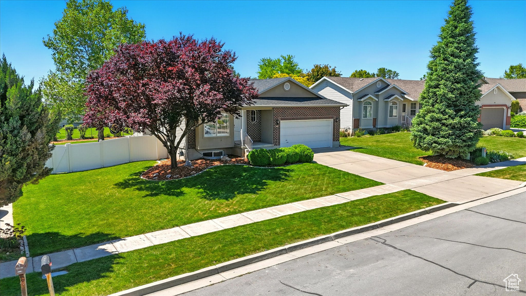 Obstructed view of property featuring an attached garage, driveway, brick siding, and a shingled roof