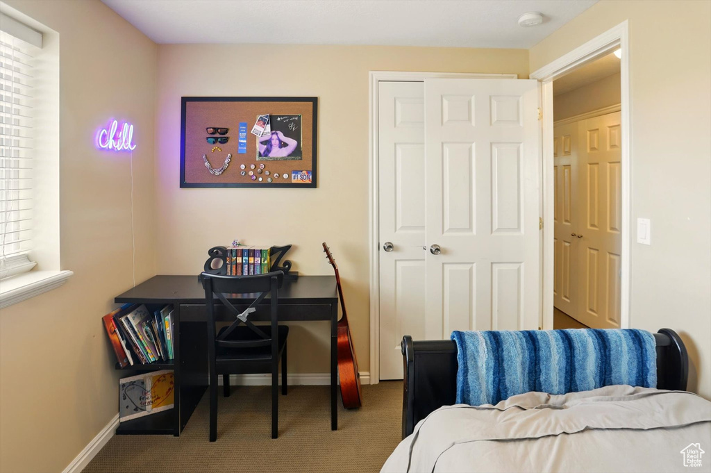Bedroom featuring carpet and baseboards