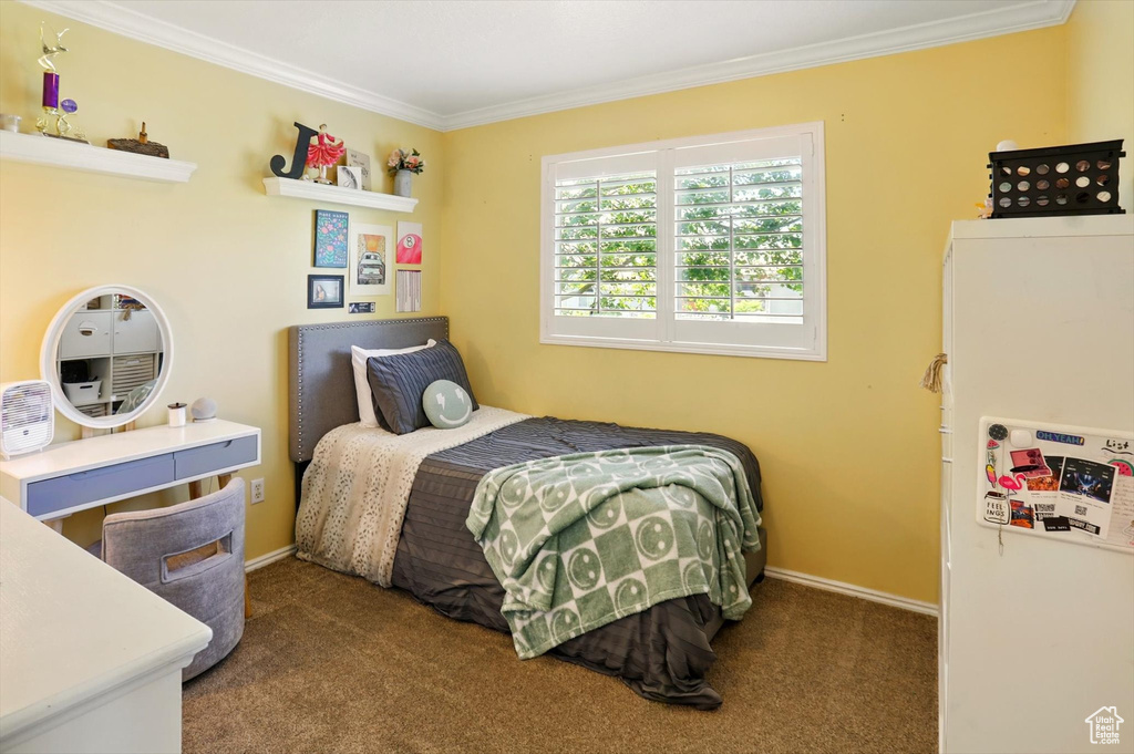 Carpeted bedroom with ornamental molding and baseboards
