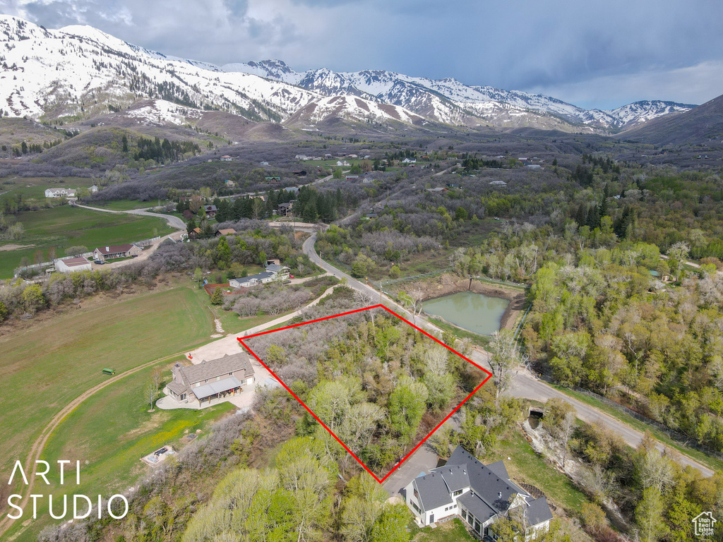 Aerial view of property and surrounding area featuring property boundaries highlighted and a mountainous background