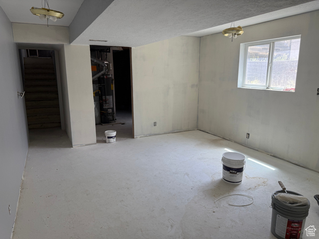 Basement featuring water heater and stairway