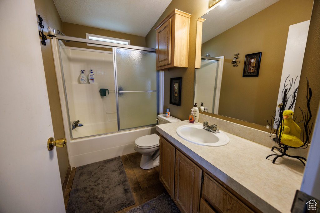 Full bathroom featuring vanity, toilet, tile patterned floors, shower / bath combination with glass door, and lofted ceiling