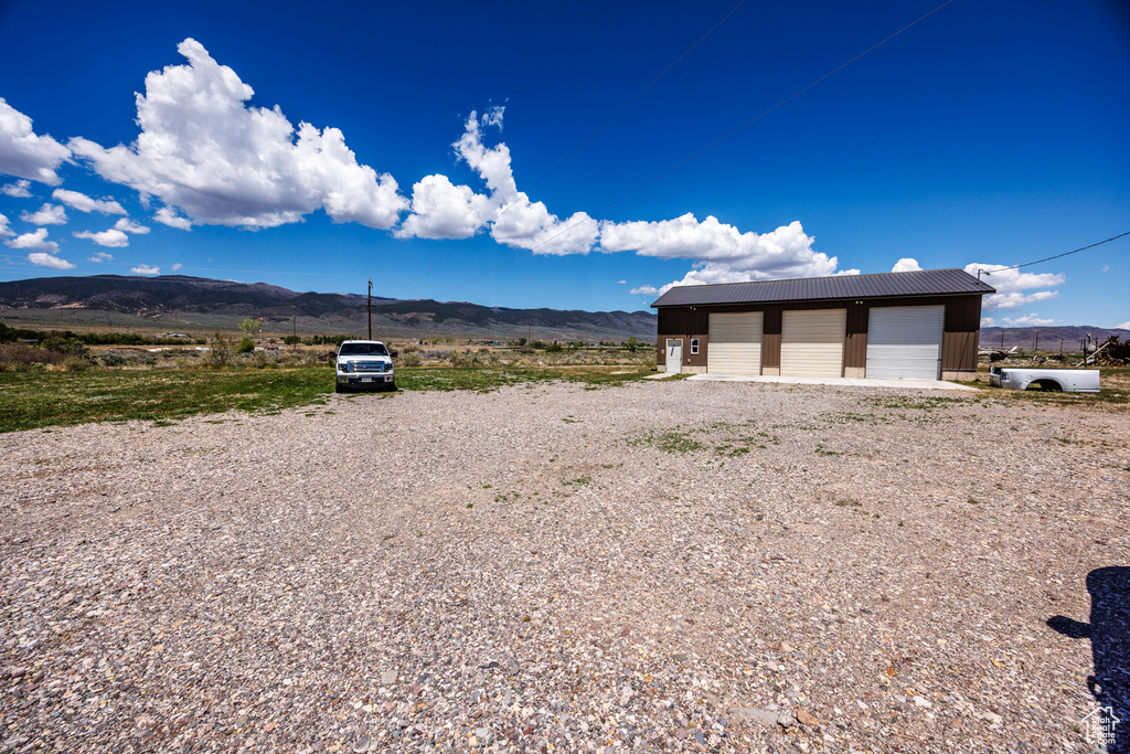 View of yard featuring a mountain view, a garage, and an outdoor structure