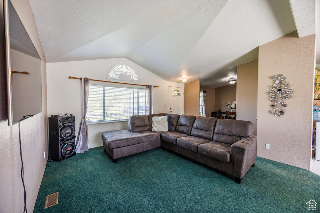 Carpeted living area featuring lofted ceiling