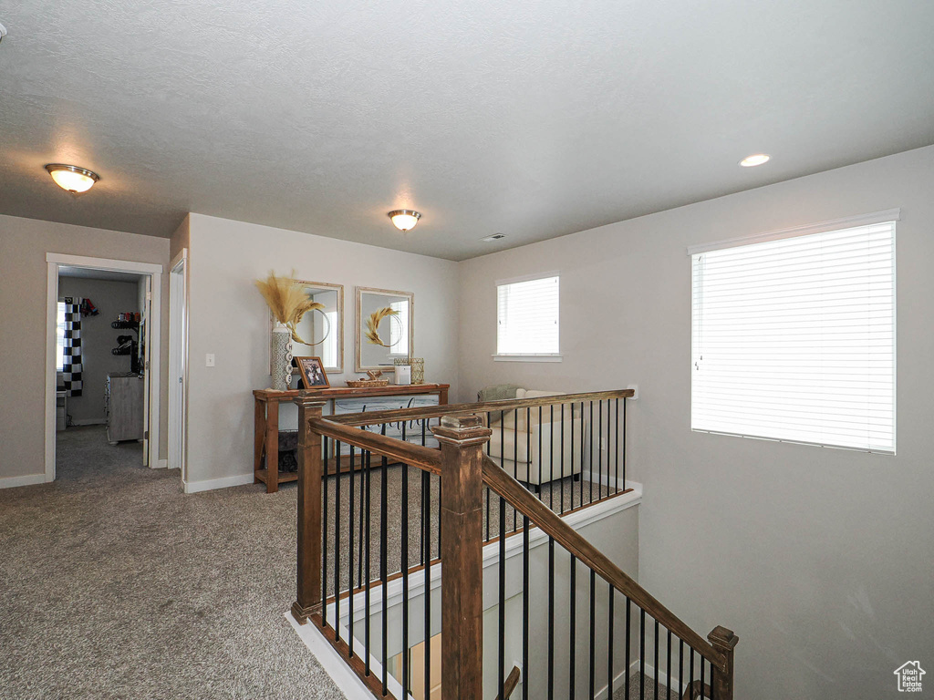 Corridor featuring an upstairs landing, baseboards, carpet flooring, and recessed lighting