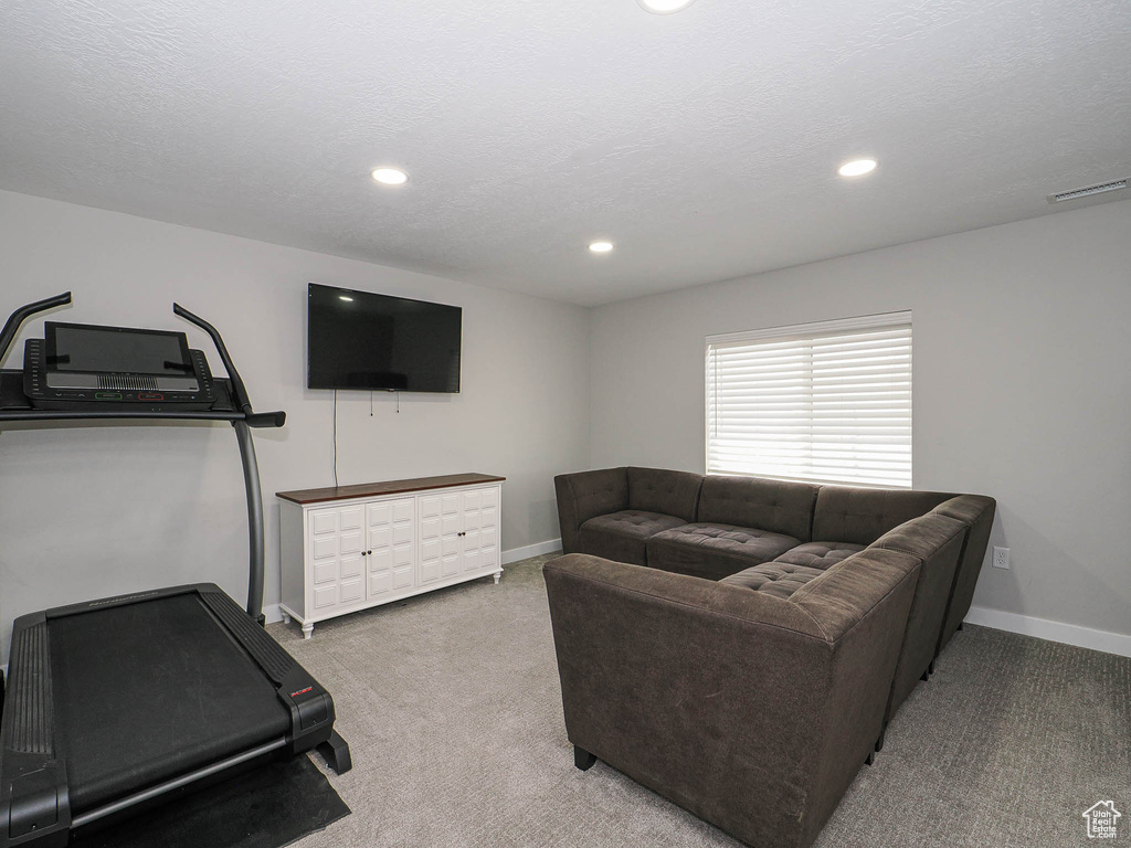 Living area with carpet floors, baseboards, and recessed lighting