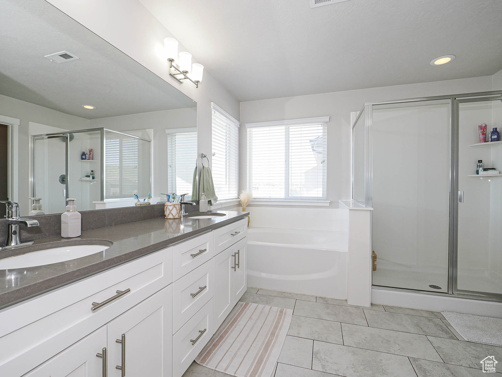 Full bath featuring a shower stall, double vanity, a bath, tile patterned floors, and recessed lighting