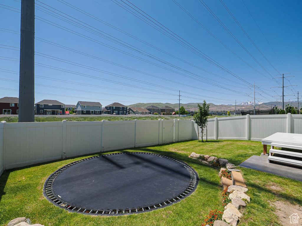 View of yard featuring a trampoline and a residential view