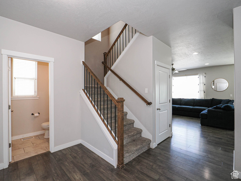 Stairway featuring a textured ceiling, wood finished floors, ceiling fan, baseboards, and recessed lighting