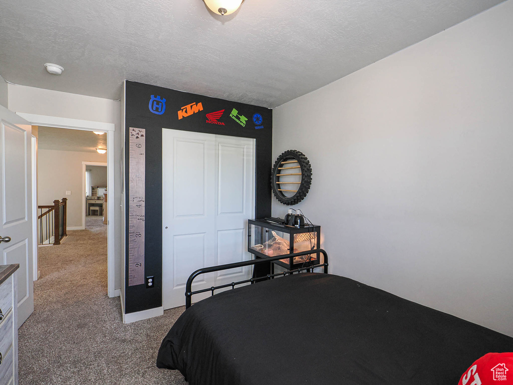Carpeted bedroom with a closet and a textured ceiling