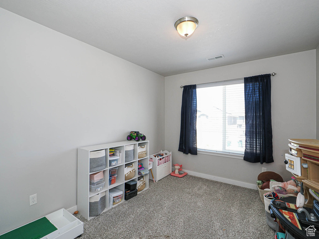 Recreation room featuring baseboards and carpet
