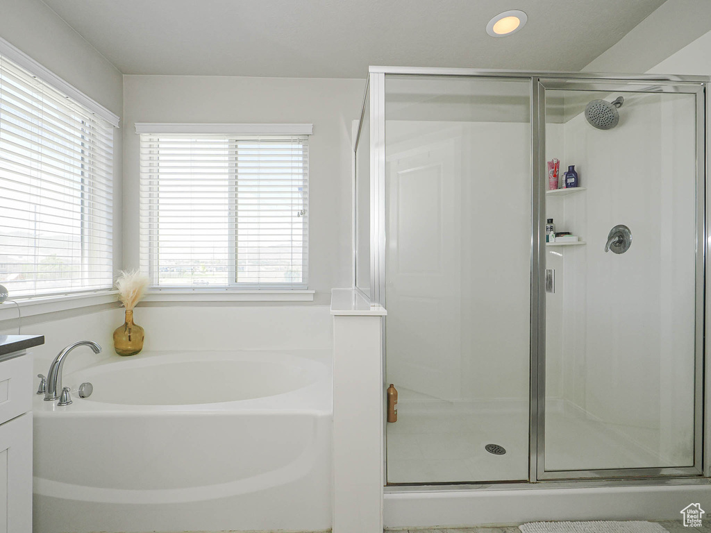 Bathroom featuring a garden tub, a shower stall, and recessed lighting