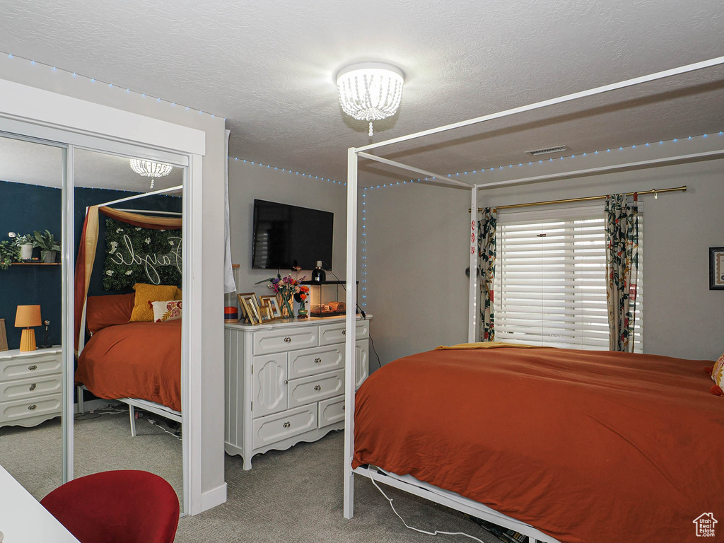 Bedroom featuring carpet flooring and a chandelier