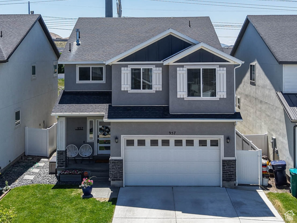 View of front facade with concrete driveway, a garage, board and batten siding, and roof with shingles