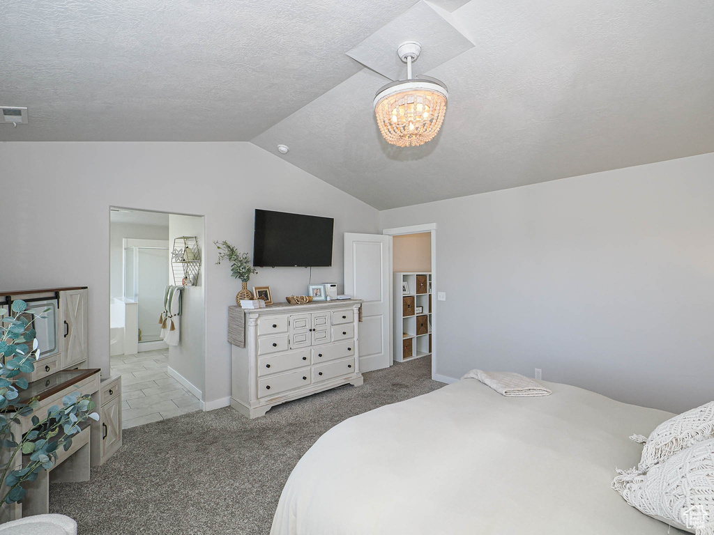 Carpeted bedroom featuring lofted ceiling, a chandelier, baseboards, and a textured ceiling