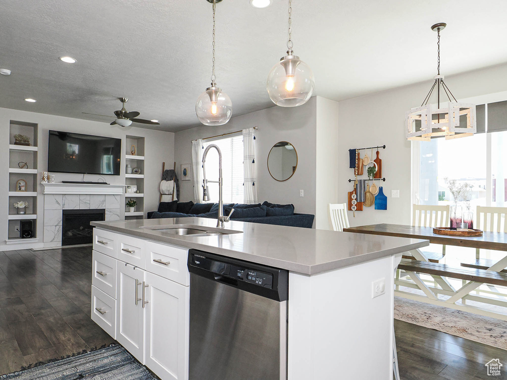 Kitchen featuring dishwasher, a sink, a ceiling fan, dark wood finished floors, and open floor plan