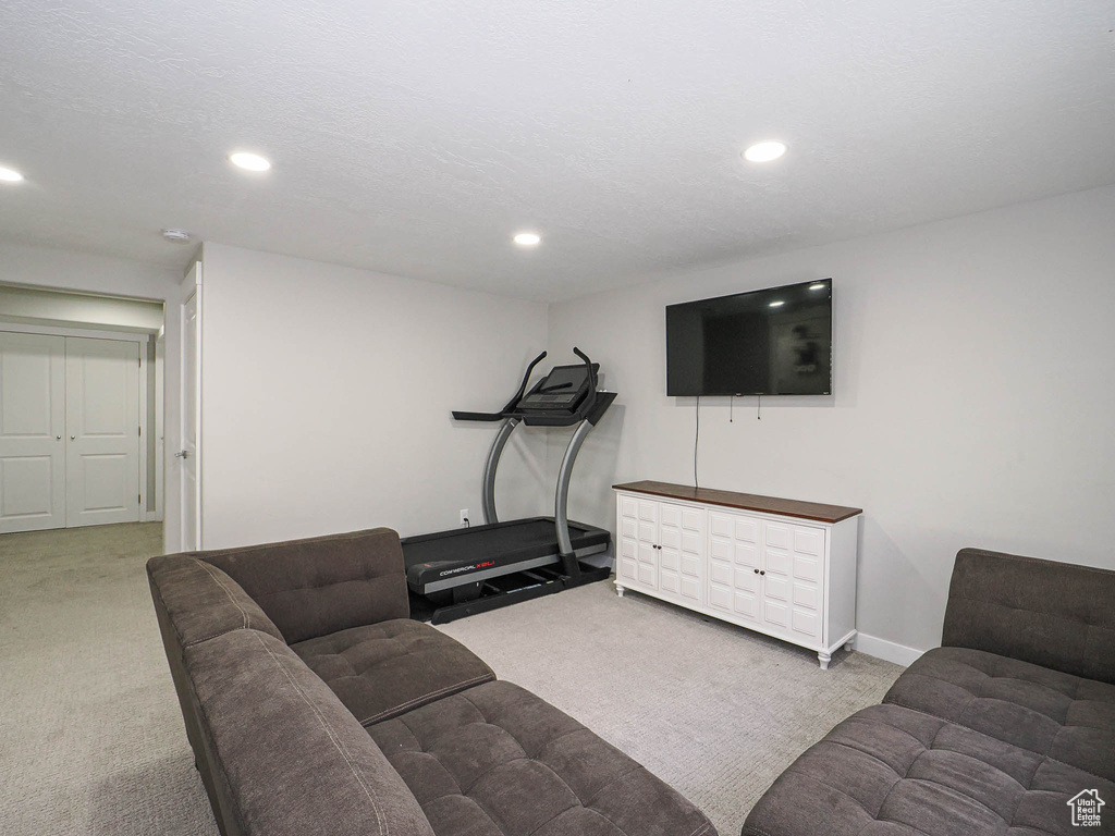 Carpeted living area featuring recessed lighting and baseboards