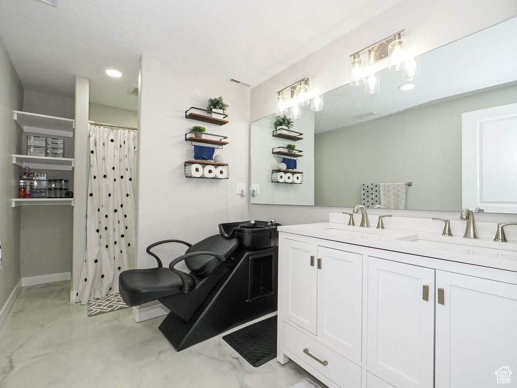 Full bathroom with double vanity, baseboards, recessed lighting, a shower with shower curtain, and finished concrete floors