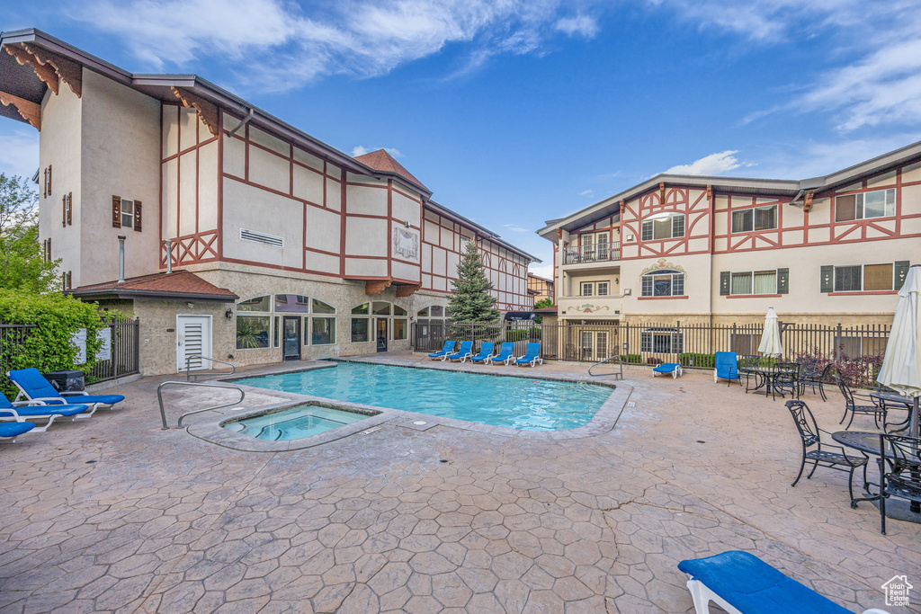 Community pool featuring a hot tub and a patio area