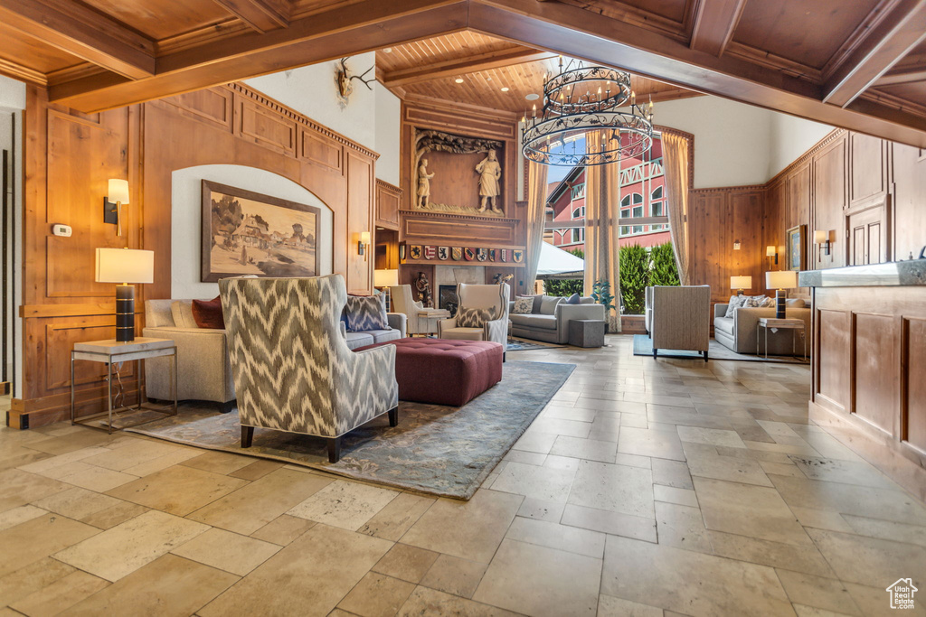 Building lobby featuring wooden ceiling with exposed beams, a high ceiling, and wooden walls