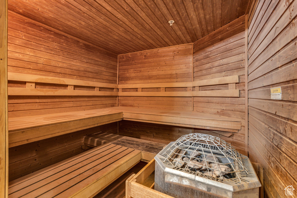 Relaxing sauna featuring wooden walls and wooden ceiling