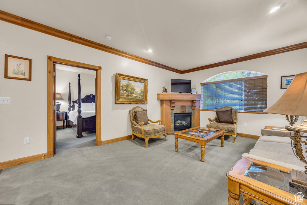 Living room with ornamental molding, carpet, baseboards, a glass covered fireplace, and recessed lighting