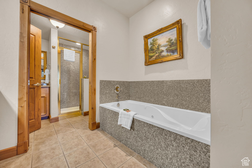 Full bathroom featuring a shower stall, tile patterned flooring, and a jetted tub