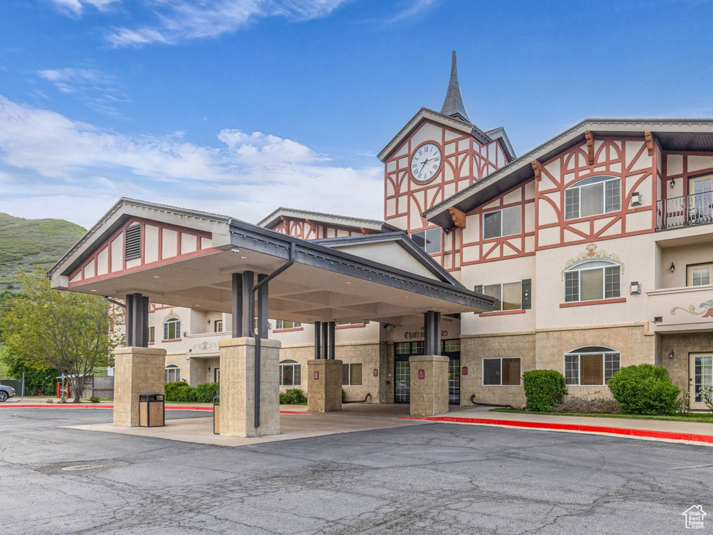 View of property with uncovered parking and a mountain view