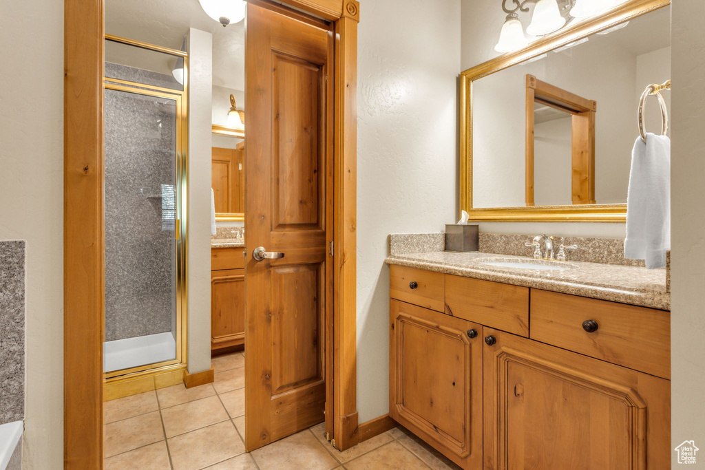 Bathroom with a stall shower, vanity, and tile patterned flooring