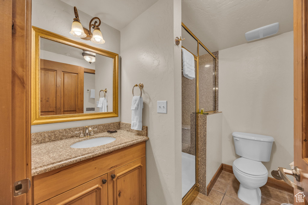 Full bathroom featuring vanity, a shower stall, toilet, and tile patterned floors