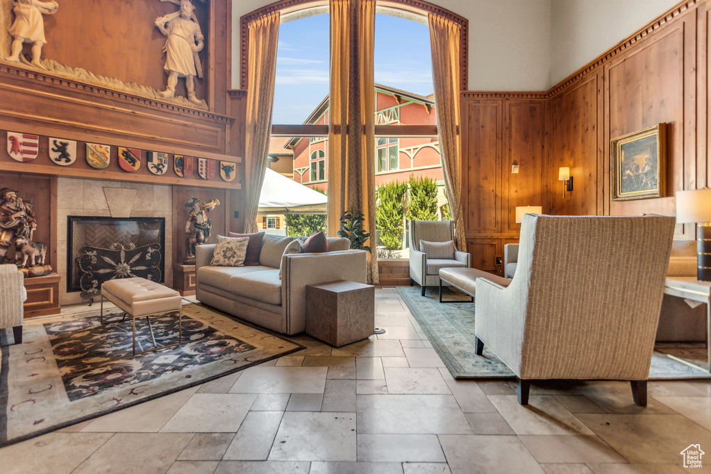 Living area featuring stone tile floors, wooden walls, and a tiled fireplace