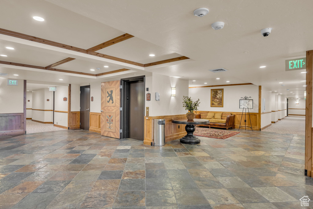 Community lobby with a wainscoted wall, a surveillance system, and recessed lighting