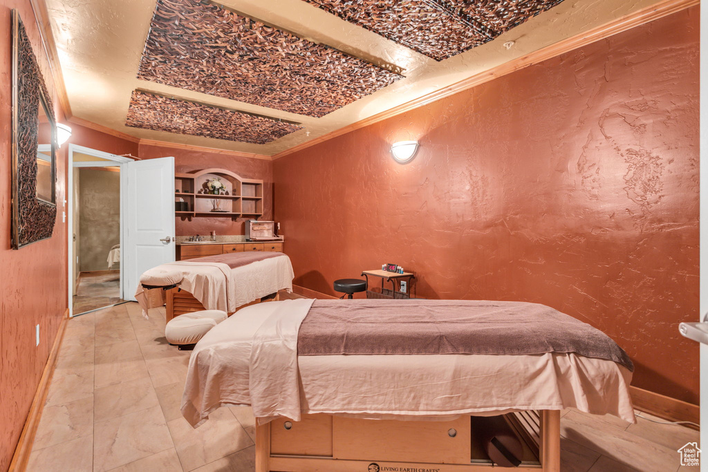 Bedroom featuring crown molding, a textured wall, and baseboards