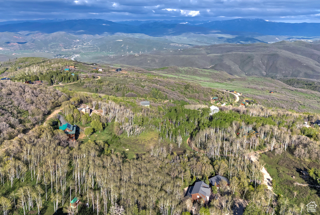 Aerial view of property and surrounding area with a mountainous background