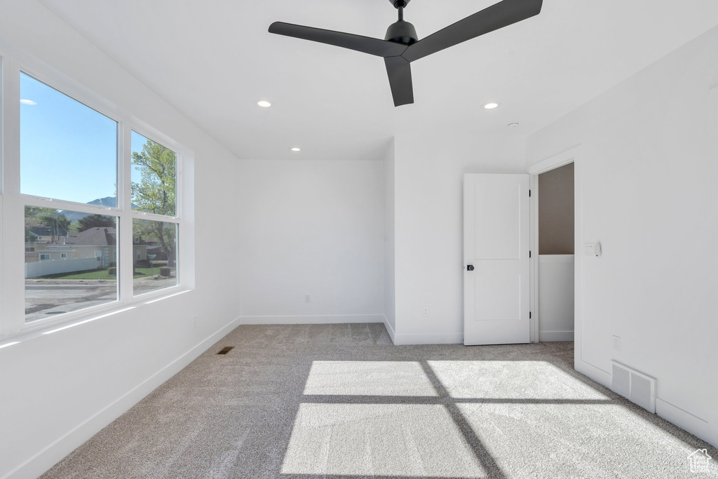 Carpeted empty room with baseboards, ceiling fan, and recessed lighting