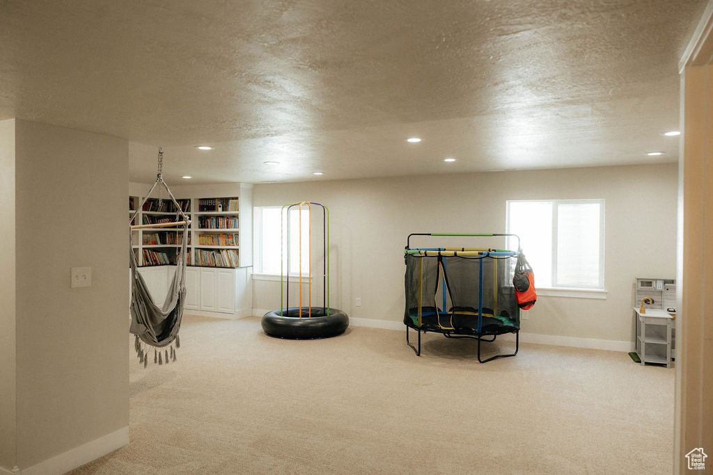 Recreation room featuring baseboards, carpet floors, plenty of natural light, recessed lighting, and a textured ceiling