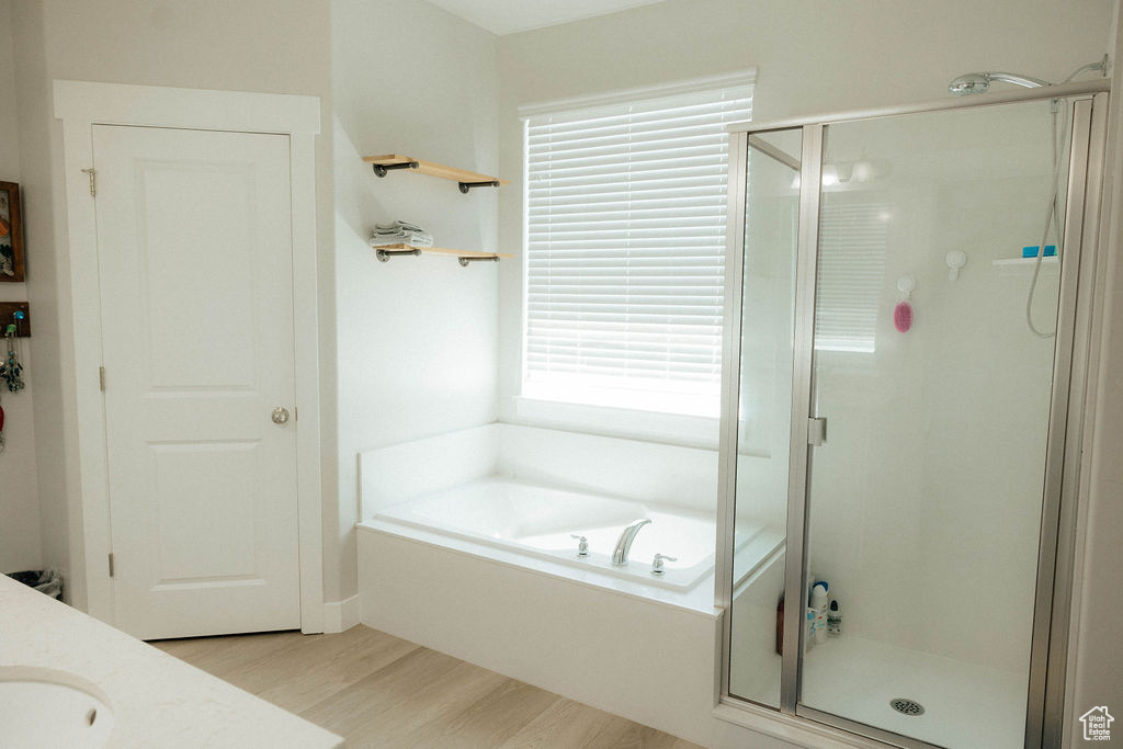 Full bath with wood finished floors, a shower stall, a garden tub, and vanity