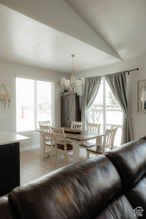 Dining area featuring a chandelier, light wood-style floors, and baseboards