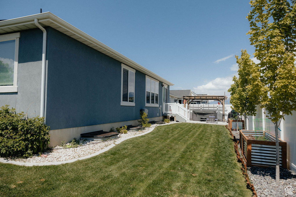 View of grassy yard with a covered hot tub