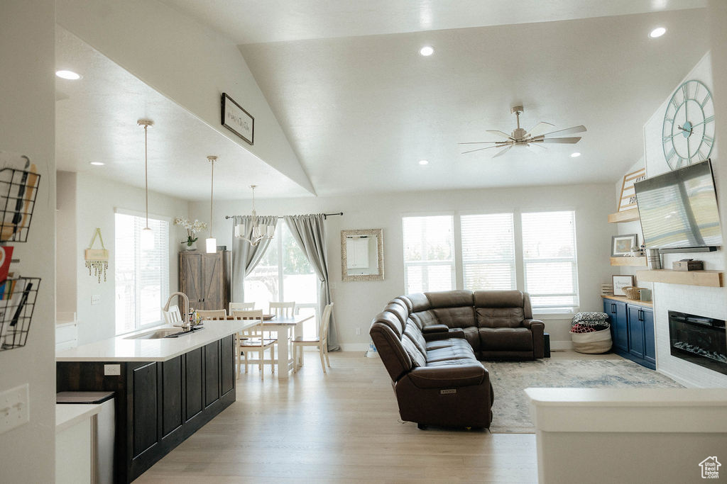 Living room featuring healthy amount of natural light, a ceiling fan, light wood finished floors, baseboards, and recessed lighting
