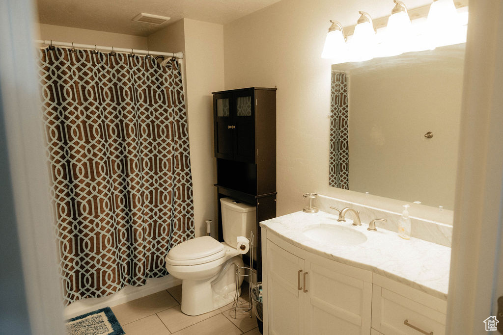 Full bath with tile patterned flooring, toilet, vanity, and a shower with shower curtain